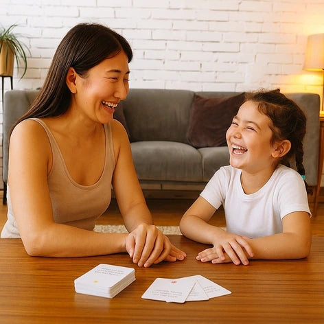 Mother and daughter laughing together while playing with the Tell Me Cards conversation deck